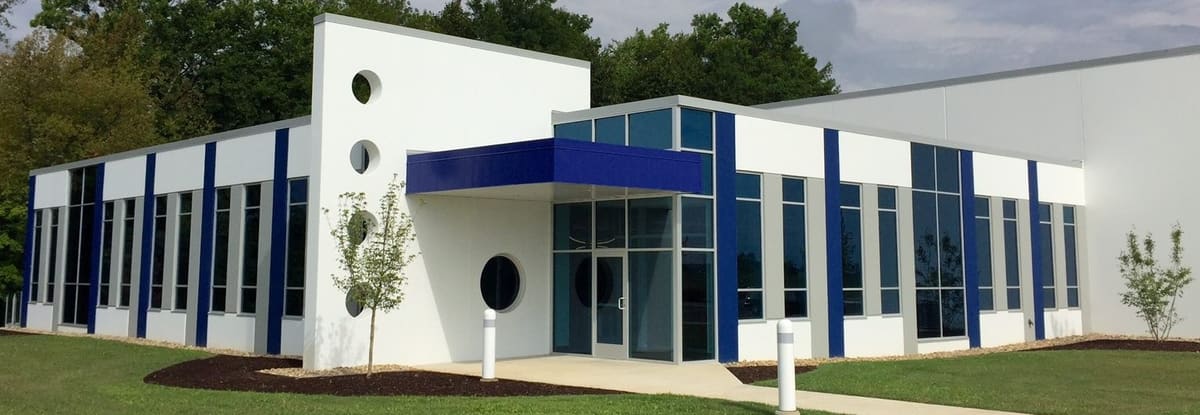 Our building in Hudsonville: white walls with blue stripes and a blue entrance canopy